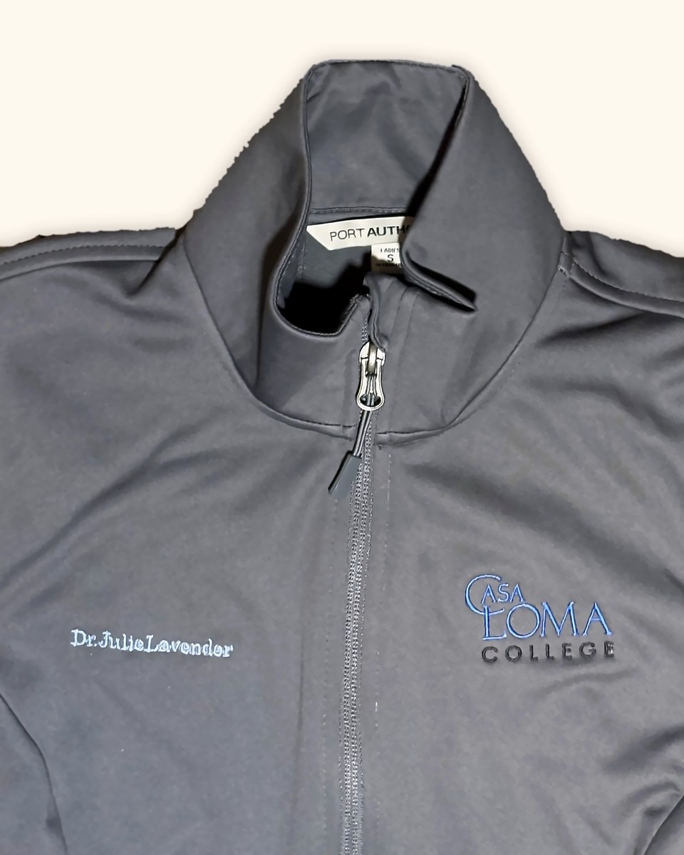 Grey soft shell jacket embroidered with a name and a college crest logo